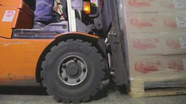 Depodan geçen bir forkliftin yakın çekimi. Forklift hareket halinde, yakın plan. Forklift tekerlekleri yakın çekim.