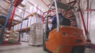 Forklift fabrikanın deposundan geçiyor. Modern depo. Fabrikada büyük bir depo. Depo çalışması.