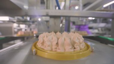 Kek konveyör çizgisinde. Pasta üretimi. Modern bir fabrikada kek üretimi. Otomatik pasta oluşturma süreci.