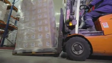 Forklift fabrikanın deposundan geçiyor. Modern depo. Fabrikada büyük bir depo. Depo çalışması.
