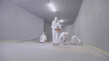 Creating a self-leveling floor in the parking lot. Creation of self-leveling floors. Builders make self-leveling floors in the parking lot.