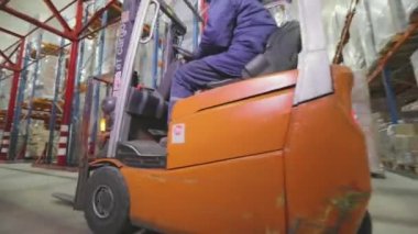 Forklift fabrikanın deposundan geçiyor. Modern depo. Fabrikada büyük bir depo. Depo çalışması.