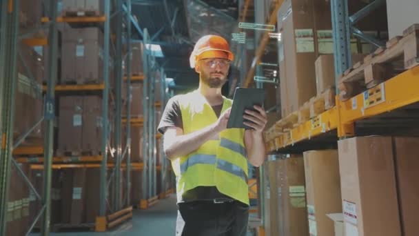 倉庫にタブレットを持っている男 工場の倉庫内の近代的な技術の可視化 倉庫内の未来技術 — ストック動画