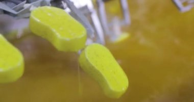 Ice cream is dipped into a container with fruit glaze. Colorful bright ice cream on the conveyor. Ice cream production.