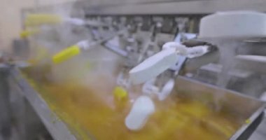 Ice cream is dipped into a container with fruit glaze. Colorful bright ice cream on the conveyor. Ice cream production.