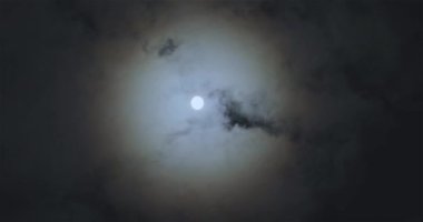 Full moon behind clouds. Full moon. The movement of the clouds against the background of the full moon.
