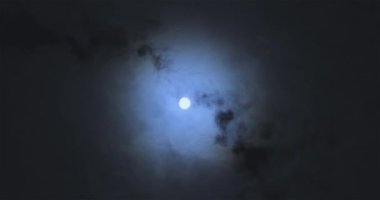 Full moon behind clouds. Full moon. The movement of the clouds against the background of the full moon.