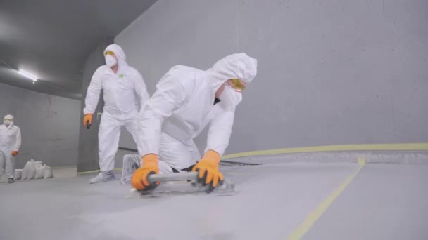 Builder Smoothes Surface Floor Spatula Builder Protective Suit Creates Polymer — Stock Video