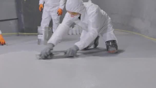 Builder Smoothes Surface Floor Spatula Builder Protective Suit Creates Polymer — Αρχείο Βίντεο