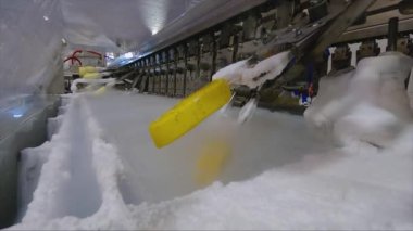 Ice cream is dipped into a container with fruit glaze. Colorful bright ice cream on the conveyor. Ice cream production.