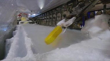 Ice cream is dipped into a container with fruit glaze. Colorful bright ice cream on the conveyor. Ice cream production.