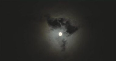 Full moon behind clouds. Full moon. The movement of the clouds against the background of the full moon.