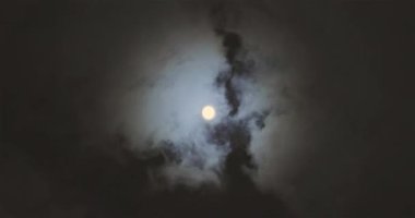 Full moon behind clouds. Full moon. The movement of the clouds against the background of the full moon.