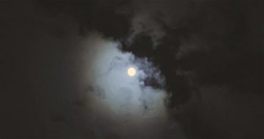 Full moon behind clouds. Full moon. The movement of the clouds against the background of the full moon.