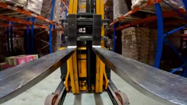 Forklift çatalı yakın çekim. Yük taşıyıcı depoya biniyor. Modern forklift büyük bir depoda..
