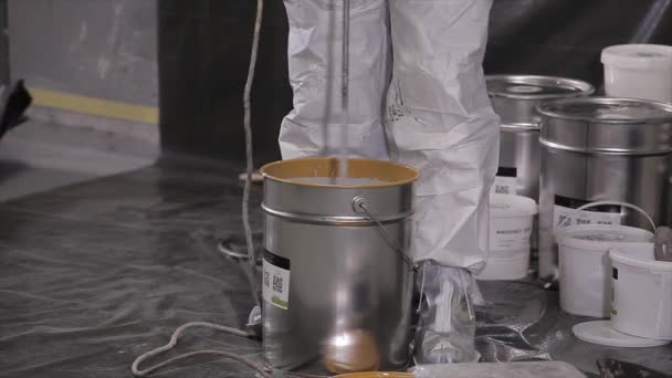 建筑商把建筑物的混合物搅拌在桶里 建筑工人在建筑用桶里搅拌油漆 — 图库视频影像