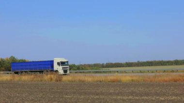 Kamyon güneşli havada otoyol boyunca sürer. Kamyon modern bir yolda gidiyor. Pistte kamyon var.