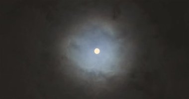 Full moon behind clouds. Full moon. The movement of the clouds against the background of the full moon.