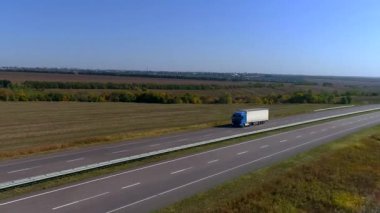 Kamyon güneşli havada otoyol boyunca sürer. Kamyon modern bir yolda gidiyor. Pistte kamyon var.
