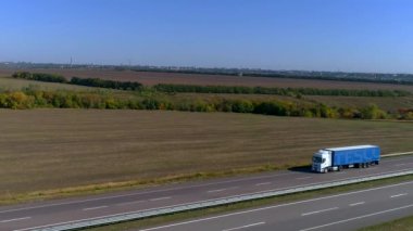 Kamyon güneşli havada otoyol boyunca sürer. Kamyon modern bir yolda gidiyor. Pistte kamyon var.