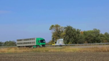Kamyon güneşli havada otoyol boyunca sürer. Kamyon modern bir yolda gidiyor. Pistte kamyon var.