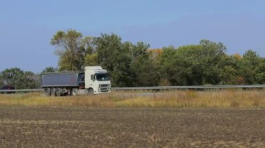 Nakliye aracı. Kamyon güneşli havada otoyol boyunca sürer. Kamyon modern bir yolda gidiyor. Pistte kamyon var