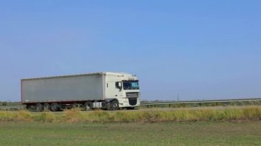 Kamyon otoyolda gidiyor. Kamyon tarlaların etrafındaki otoyolda gidiyor..