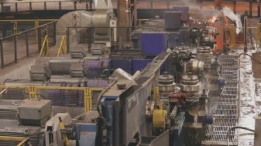 Modern bir taşıma hattında sıcak metal. Taşıyıcıda su ile metal soğutma. Yuvarlanırken kırmızı sıcak metal.