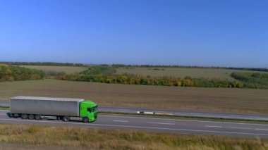 Kamyon güneşli havada otoyol boyunca sürer. Kamyon modern bir yolda gidiyor. Pistte kamyon var.