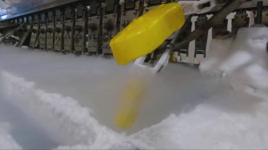 Ice cream is dipped into a container with fruit glaze. Colorful bright ice cream on the conveyor. Ice cream production.