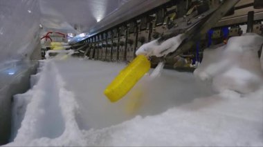Ice cream is dipped into a container with fruit glaze. Colorful bright ice cream on the conveyor. Ice cream production.
