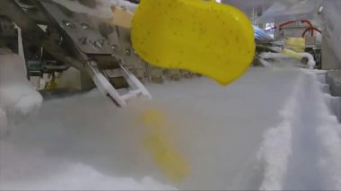 Ice cream is dipped into a container with fruit glaze. Colorful bright ice cream on the conveyor. Ice cream production.
