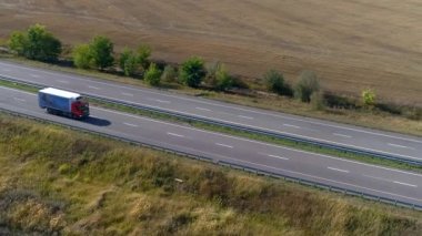 Kamyon güneşli havada otoyol boyunca sürer. Kamyon modern bir yolda gidiyor. Pistte kamyon var.