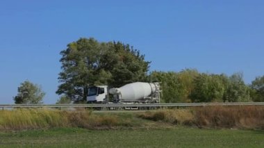 Betonlu bir kamyon otoyol boyunca sürüyor. Kamyon ile beton taşımacılığı.