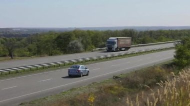 Kamyon güneşli havada otoyol boyunca sürer. Kamyon modern bir yolda gidiyor. Pistte kamyon var.