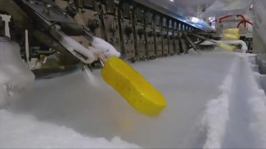 Ice cream is dipped into a container with fruit glaze. Colorful bright ice cream on the conveyor. Ice cream production.