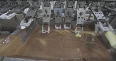 The chocolate drips nicely off the ice cream. Chocolate dripping from ice cream slow motion. Ice cream is dipped in chocolate at the factory.