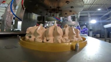 Otomatik dondurma üretimi. Dondurmalı pasta yapmak için otomatik taşıyıcı. Dondurma tüplerden güzelce çıkarılmış..