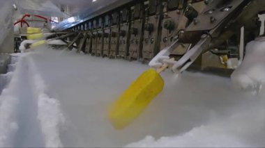 Ice cream is dipped into a container with fruit glaze. Colorful bright ice cream on the conveyor. Ice cream production.