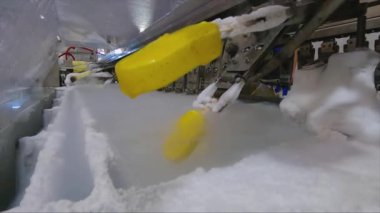 Ice cream is dipped into a container with fruit glaze. Colorful bright ice cream on the conveyor. Ice cream production.