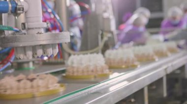 Otomatik dondurma üretimi. Dondurmalı pasta yapmak için otomatik taşıyıcı. Dondurma tüplerden güzelce çıkarılmış..