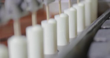 The chocolate drips nicely off the ice cream. Chocolate dripping from ice cream slow motion. Ice cream is dipped in chocolate at the factory.
