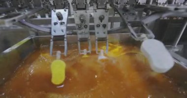Ice cream is dipped into a container with fruit glaze. Colorful bright ice cream on the conveyor. Ice cream production.