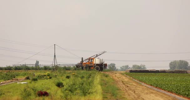 农场的设备 拖拉机与喷雾器骑在农场的土地上 拖拉机在农场上行驶 — 图库视频影像