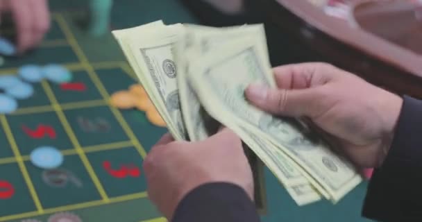 玩家数美元 赌场里的玩家数钱 数着赌场赢的钱一个男人把美元算作特写镜头 — 图库视频影像