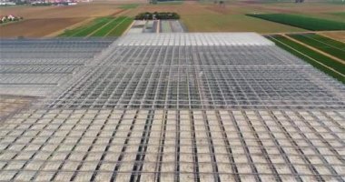 Büyük bir seranın üzerinden uçmak. Seralarda sebze yetiştiriyor. Büyük, modern bir sera. seralar hava görüntüsü.