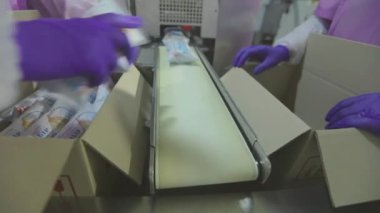 İşçiler kutulara dondurma koyarlar. Kadınlar dondurmaları kutulara koyar. Fabrika iş akışı.