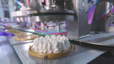 Otomatik dondurma üretimi. Dondurmalı pasta yapmak için otomatik taşıyıcı. Dondurma tüplerden güzelce çıkarılmış..
