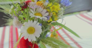 Festival masasında bir buket çiçek. Masada güzel çiçekler var. Masada bir buket çiçek var..