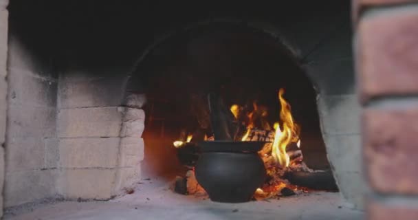 木製の燃えるオーブンのカルドロン 木製の燃えるストーブで鋳鉄ボイラー オールドウッドストーブ 食べ物は調理していますが オーブンで火にかけます — ストック動画